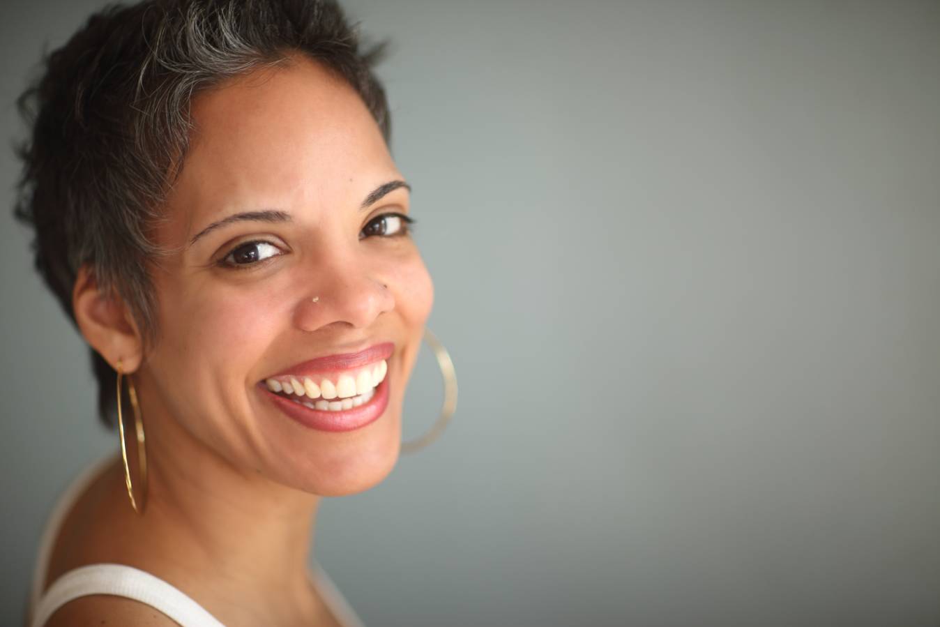 A woman smiling with her head turned to the side.