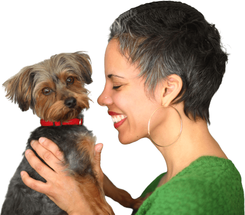 A woman holding onto her dog with both hands