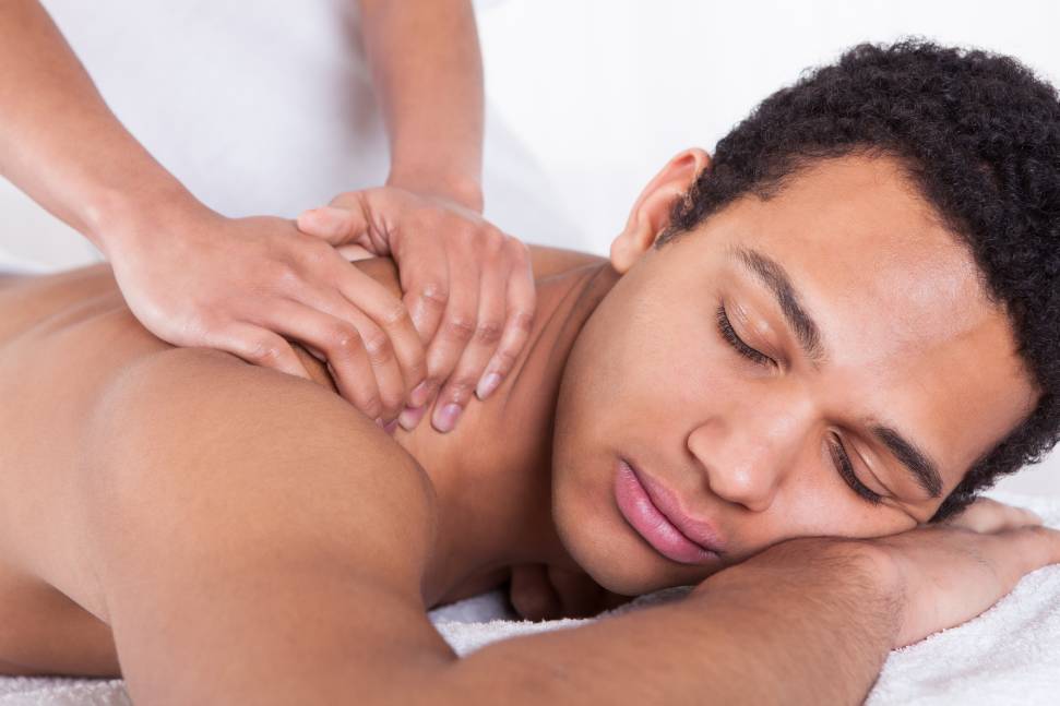 A man getting his back touched by a masseuse.