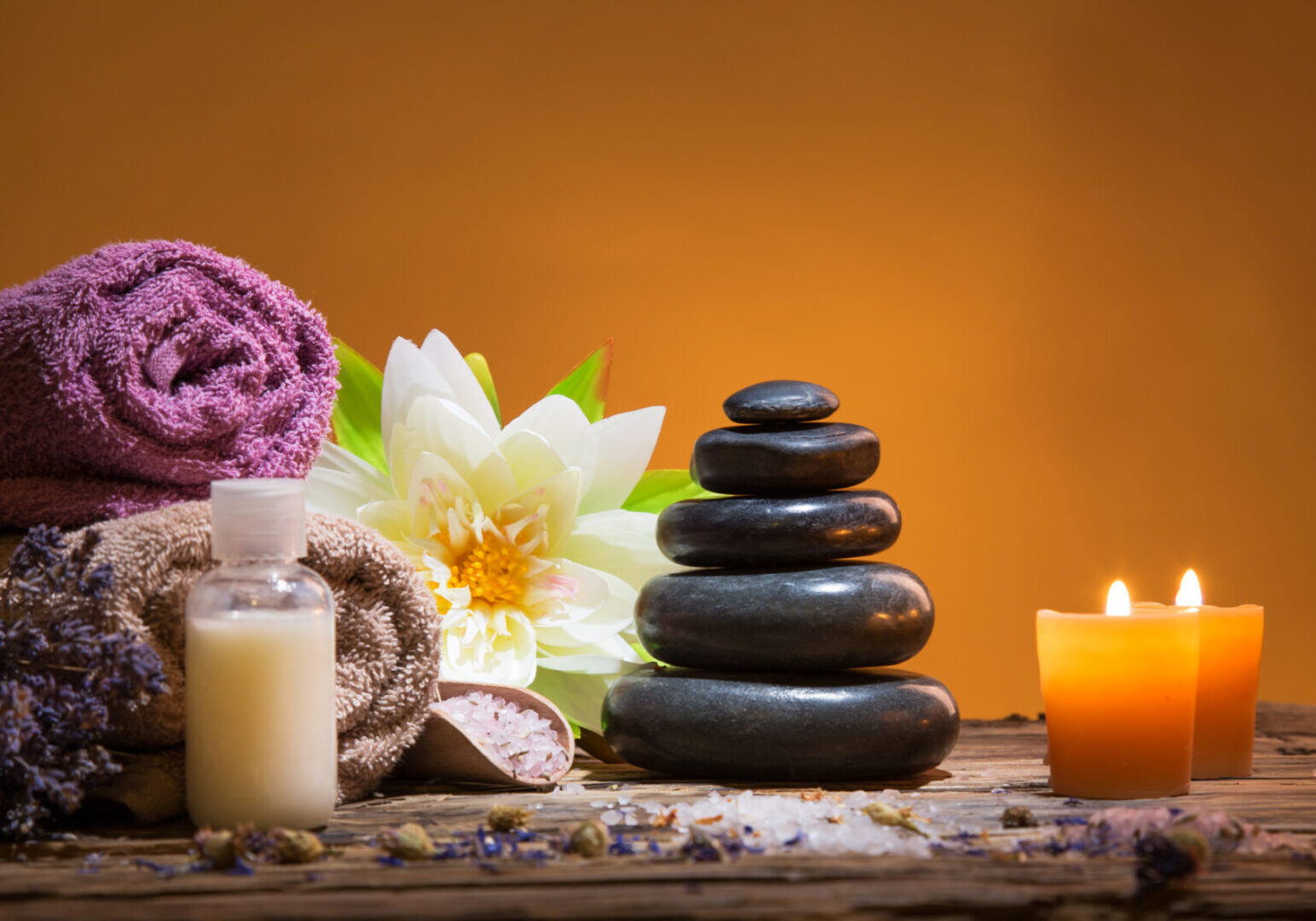 Spa still-life with stacked of stone and burning candles, close-up.